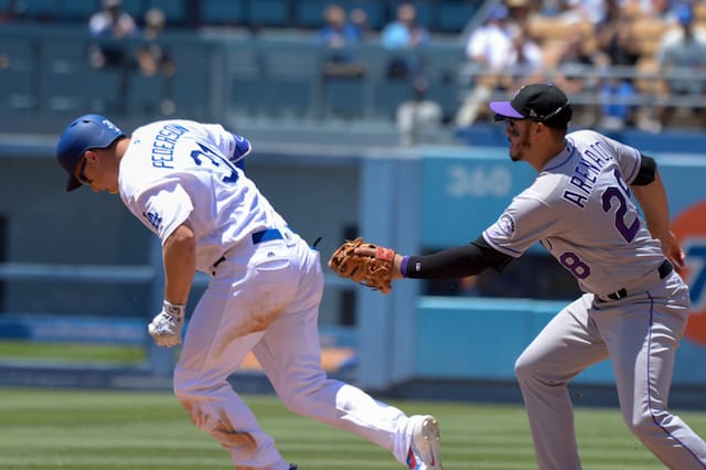 Colorado Rockies third baseman Nolan Arenado attempts to tag Los Angeles Dodgers outfielder Joc Pederson