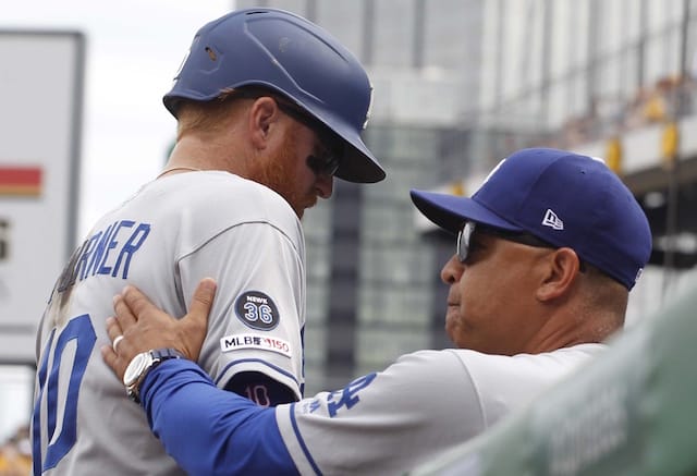 Los Angeles Dodgers manager Dave Roberts greets Justin Turner in the dugout at PNC Park