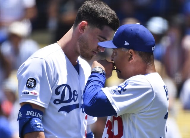 Los Angeles Dodgers manager Dave Roberts speaks with Cody Bellinger after a foul ball hits a fan at Dodger Stadium