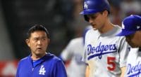 Los Angeles Dodgers manager Dave Roberts and a team trainer walk off the field with Corey Seager after his hamstring injury