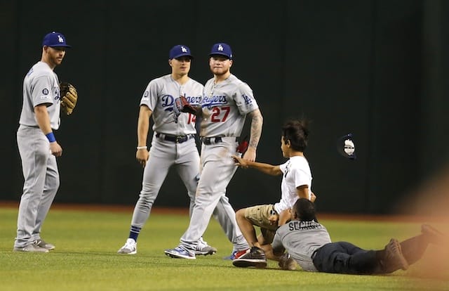 Los Angeles Dodgers outfielders Kyle Garlick, Kiké Hernandez and Alex Verdugo watch a fan get tackled by security at Chase Field