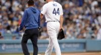 Starting pitcher Rich Hill walks off the field with a Los Angeles Dodgers trainer