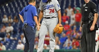 Los Angeles Dodgers closer Kenley Jansen is checked on by a trainer after being hit by a comebacker