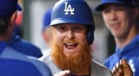 Los Angeles Dodgers pitcher Walker Buehler looks on as Justin Turner is congratulated in the dugout
