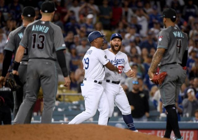 Los Angeles Dodgers first base coach George Lombard restrains Russell Martin
