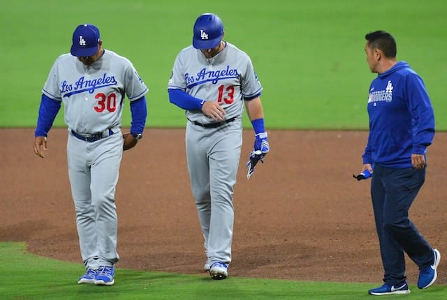 Los Angeles Dodgers infielder Max Muncy walks off the field with manager Dave Roberts and a trainer after being hit by a pitch
