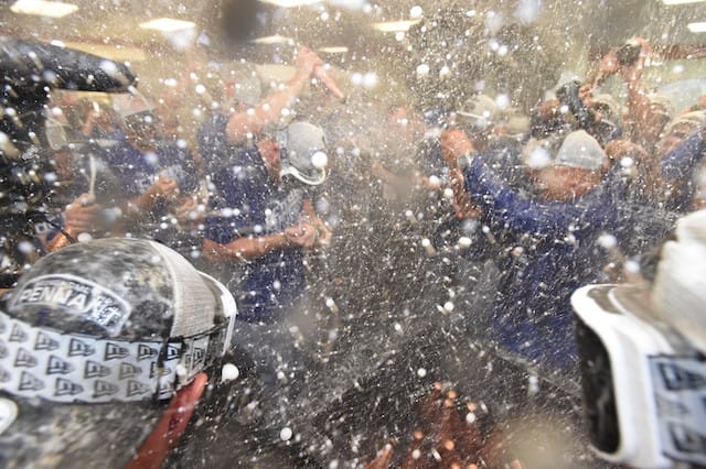 Manager Dave Roberts and the Los Angeles Dodges celebrate after clinching the NL West