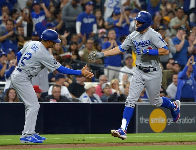 Los Angeles Dodgers third base coach Dino Ebel congratulates Chris Taylor after a home run