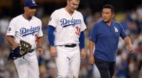 Los Angeles Dodgers manager Dave Roberts and a trainer walk off the field with Joc Pederson