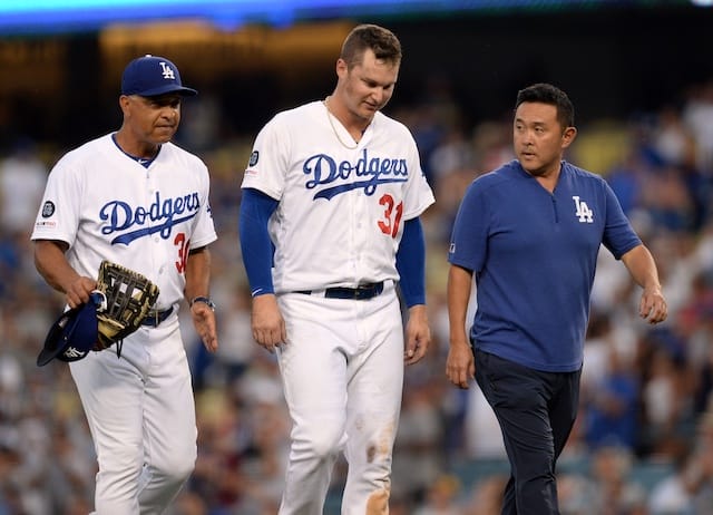 Los Angeles Dodgers manager Dave Roberts and a trainer walk off the field with Joc Pederson
